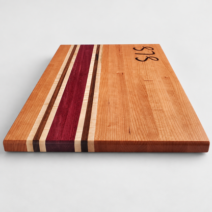 Handcrafted Cherry, Purple Heart, Walnut & Curly Maple Cutting Board, detail view on a light gray background