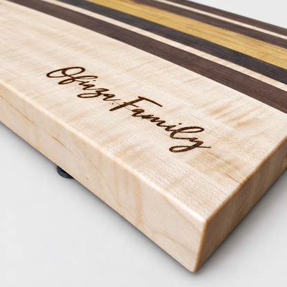 Handcrafted Curly Maple & Canary Wood Cutting Board, detail view on a light gray background