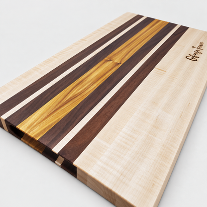 Handcrafted Curly Maple & Canary Wood Cutting Board, detail view on a light gray background