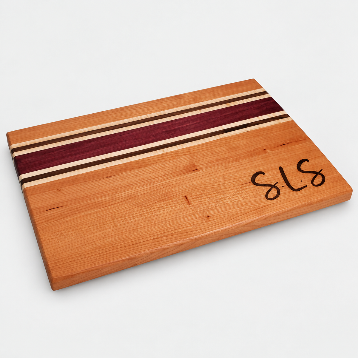 Handcrafted Cherry, Purple Heart, Walnut & Curly Maple Cutting Board on a light gray background